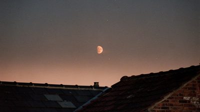 Женщина у окна с зажжённой свечой и блокнотом, ритуал воли на неделе Марса в Овне в мае 2026