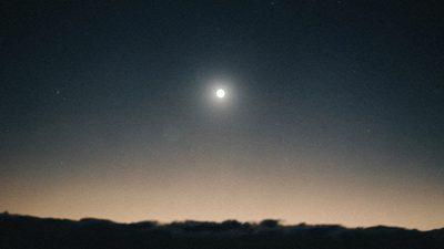 Луна в ночном небе над грядой облаков