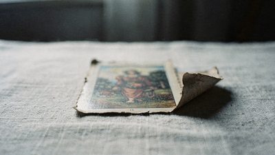 Молодая женщина задумчиво смотрит на разложенные карты таро при свете лампы